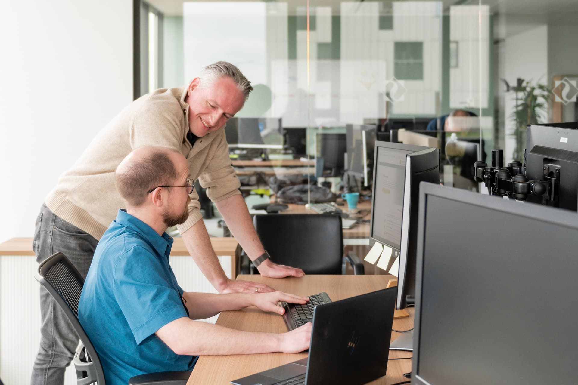 Twee medewerkers van SoftTech werken samen achter een computer